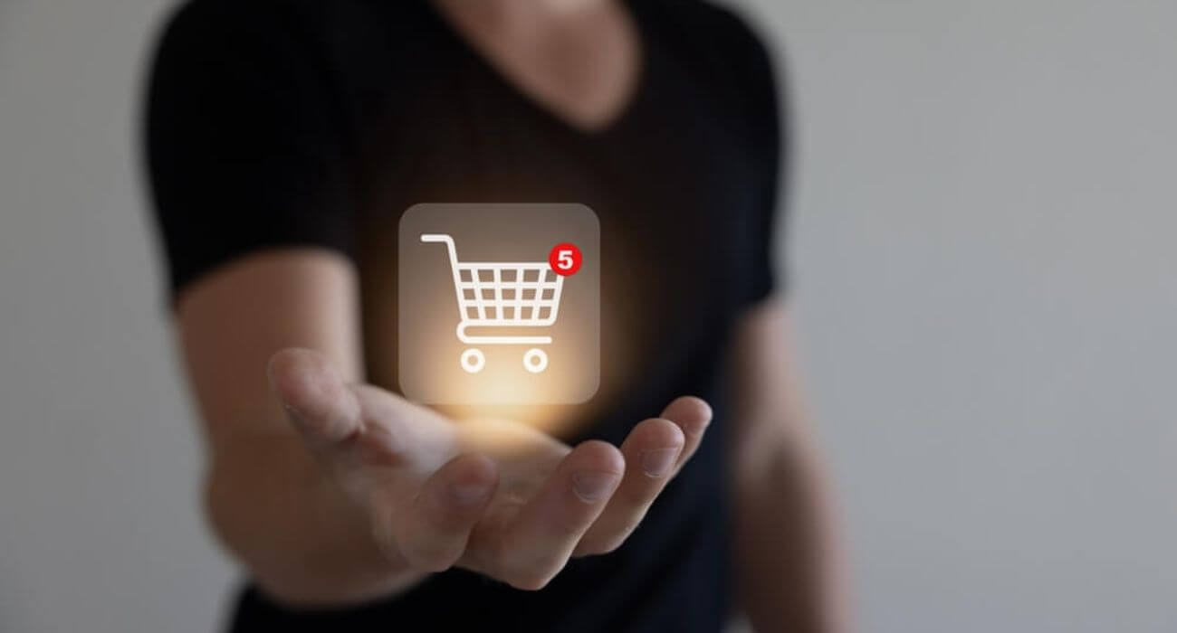 Imagem De Um Homem Com A Mão Estendida. Em Cima Dela, Há O Desenho De Um Carrinho Representando Compras Online.