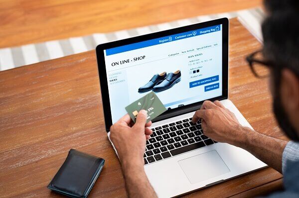 homem fazendo compra online de um calçado na promoção de ano-novo com descontos progressivos