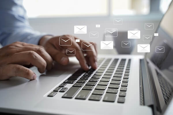 Homem digitando em notebook o título do e-mail marketing