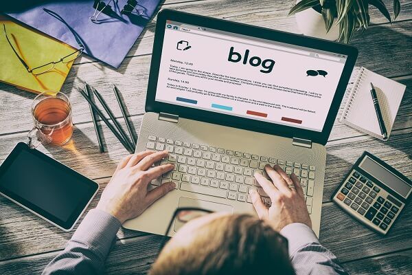 Homem trabalhando em notebook para criar conteúdo para e-commerce em um blog.