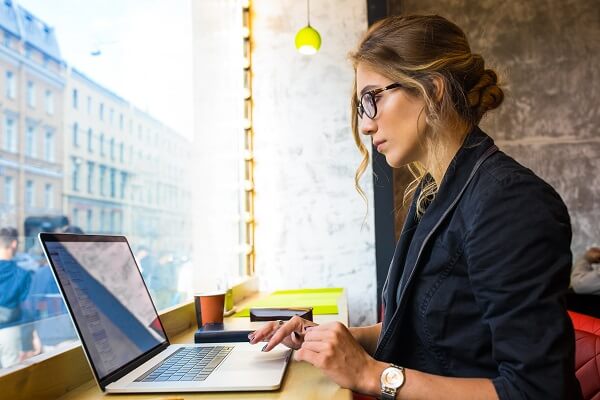 Mulher trabalhando no notebook e utilizando o marketing de conteúdo para indústria na criação da estratégia de marketing B2B.
